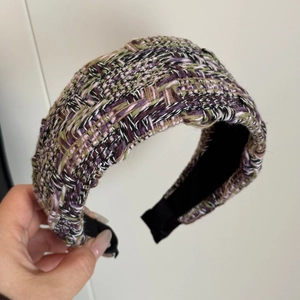 Detailed view of wide woven tweed headband in multi-color purple and green knit texture