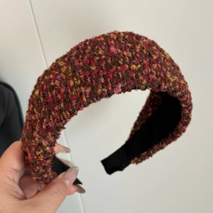 Close-up of thick tweed headband in reddish-brown mix showing rich woven texture