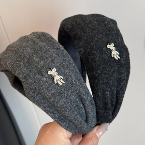 Close-up of thick winter velvet headband with silver bear charm in black and grey