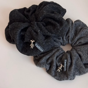 Detail of dark grey velvet hair scrunchies with silver bear charm and Fashion label