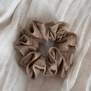 Gros plan d'un chouchou à carreaux marron en coton et lin avec étiquette Hand Made
