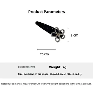 Detailed view of polka dot fabric hair clip with silver flower and sparkling rhinestones