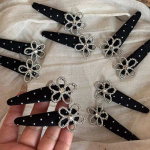 Close-up of black polka dot hair clips with silver flower and sparkling crystal details