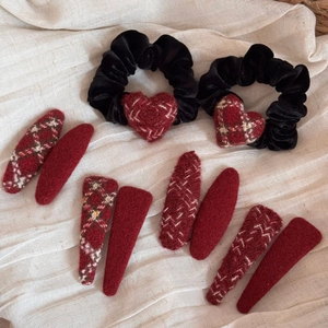 Flat lay of red checkered and black velvet hair accessories set with heart charms