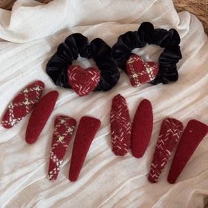Flat lay of vintage red and black plaid fabric hair clips and velvet scrunchies set