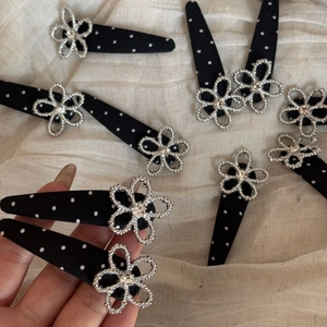 Close-up of black polka dot fabric hair clip with a sparkling silver rhinestone flower