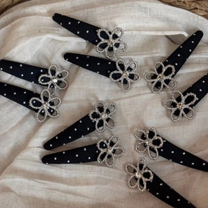 Detailed macro view of black polka dot hair clips with silver hollowed flower accents