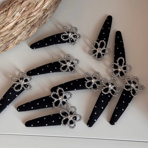 Detailed macro view of 10-piece polka dot fabric hair clips with sparkling rhinestone flowers