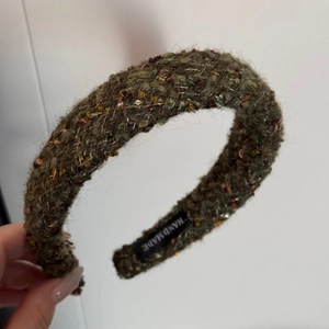 Macro view of velvet knitted headband with sequins and gold thread and handmade label