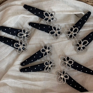 Polka dot fabric hair clips with silver flower rhinestones on soft linen background