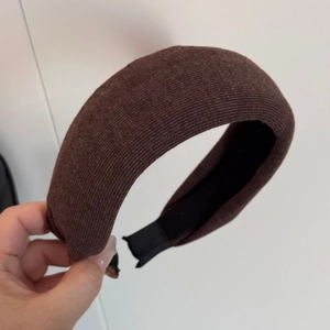 Dettaglio del cerchietto in velluto marrone con fodera antiscivolo e texture a costine