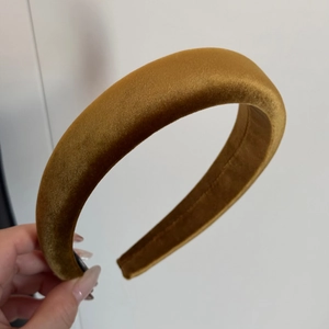 Dettaglio del cerchietto spesso in velluto giallo senape con trama morbida e lucida