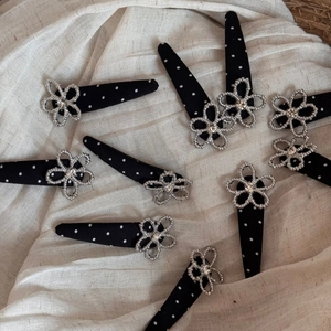 Detailed macro of black fabric polka dot hair clips with silver crystal flower charms