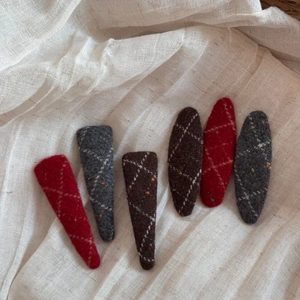 Detailed view of six felt hair clips with diamond stitching and colorful dot patterns