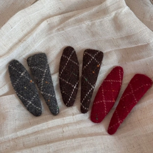 Close-up of wool felt snap hair clips with quilted diamond patterns in soft colors