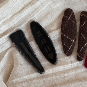 Close-up of wool plaid hair clips with dark brown texture and sturdy metal duckbill base