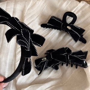 Handmade black velvet hair clip set with white polka dots on soft linen background