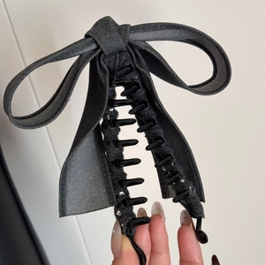 Gros plan d'une grande pince à cheveux en denim gris avec des accents de strass brillants
