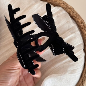 Detail of a large velvet hair claw clip with black and white polka dot bow decoration