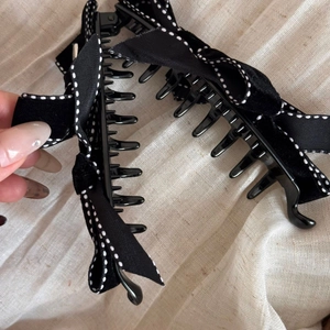 Detail of a large black velvet bow hair claw clip with white polka dot edges