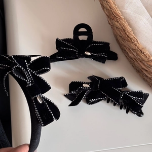 Elegant black velvet bow hair accessory set with white dotted stitching and metal tag