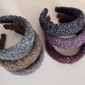 Detail of knitted wide headband with shimmering sequins and handmade woven label