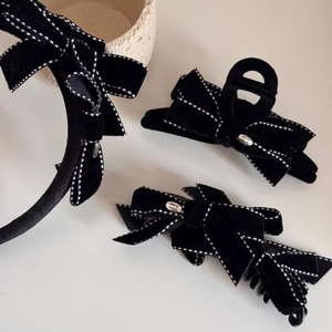 Detailed view of handmade black velvet bow hair clips with delicate white polka dot stitching