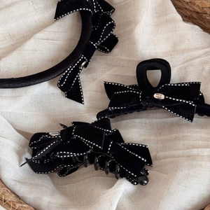 Detailed macro view of black velvet bow hair clips with handmade silver metal plate