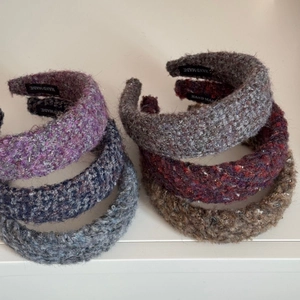 Detailed flat lay of multi-colored tweed padded headbands with hand made labels