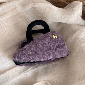 Dettaglio mini borsa in lana teddy viola con manico nero tondo e logo B in metallo dorato