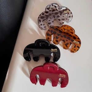 Lot de quatre pinces à cheveux léopard et unies en résine avec détail de logo doré