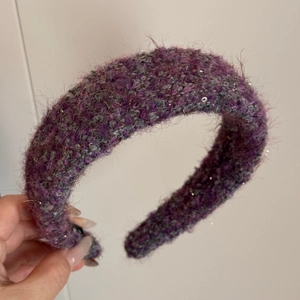 Close-up of wide plush knit headband in purple mix with silver sequins and soft texture