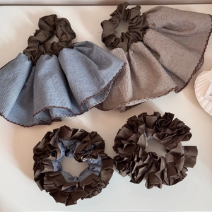 Detail showing set of four striped hair scrunchies in coffee and blue-grey fabrics