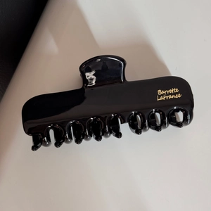 Détail de la pince à cheveux noire brillante avec le logo doré Barrette LaFrance