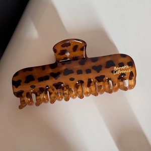 Détail d'une pince à cheveux léopard avec marquage doré Barrette LaFrance et motif ambre