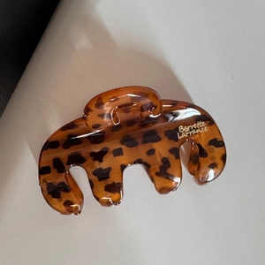 Gros plan d'une pince à cheveux en acétate à motif léopard avec une finition brillante