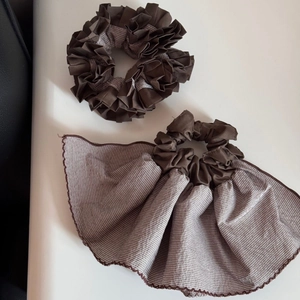 Detail of brown hair scrunchies set featuring striped fabric and layered pleats texture