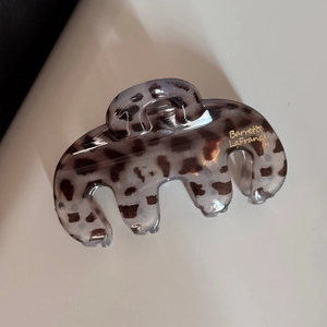 Gros plan détaillé de la pince à cheveux léopard avec le logo doré Barrette LaFrance