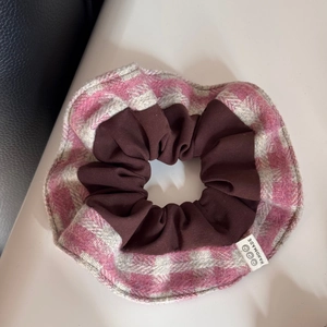 Gros plan du chouchou en tissu à carreaux roses et marron avec étiquette faite main