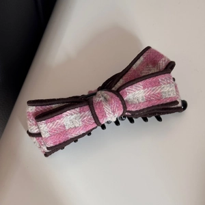 Détail de la pince à cheveux banane à carreaux roses avec nœud élégant et clip intérieur