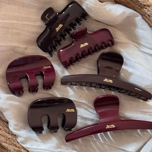 Set of 6 premium burgundy and brown shark hair claws with gold logo on white linen