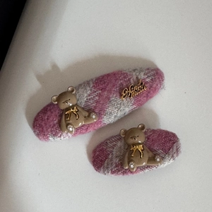 Détail de barrettes en tweed rose avec breloques ourson et étiquettes métalliques fait main