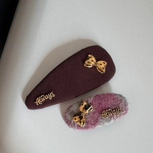 Détails de barrettes en tweed marron et rose avec accents métalliques de nœuds dorés