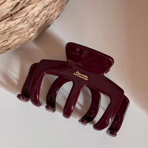 Detail of burgundy large hair claw clip with golden Barrette La France metallic text
