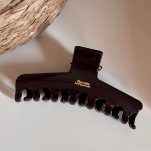 Detail view of large resin hair claw with golden Barrette La France lettering and metal hinge