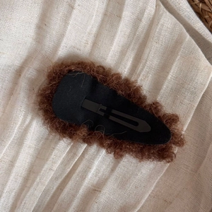 Close-up of brown plush hair clip with premium faux fur texture and black metal BB clip