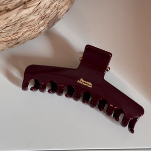 Detail view of wine red shark hair clip with golden Barrette La France text and glossy finish