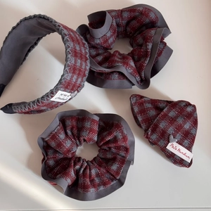Detailansicht der rot-grau karierten Haargummis und Stirnbandsatz mit Handmade-Etiketten
