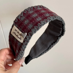 Nahaufnahme des Retro-Karo-Haargummis mit handgefertigtem Etikett und Herz-Anhänger