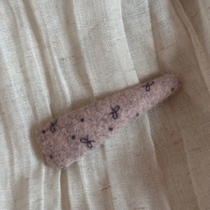 Close-up of wool fabric bow hairpin with vintage purple tone and polka dot pattern